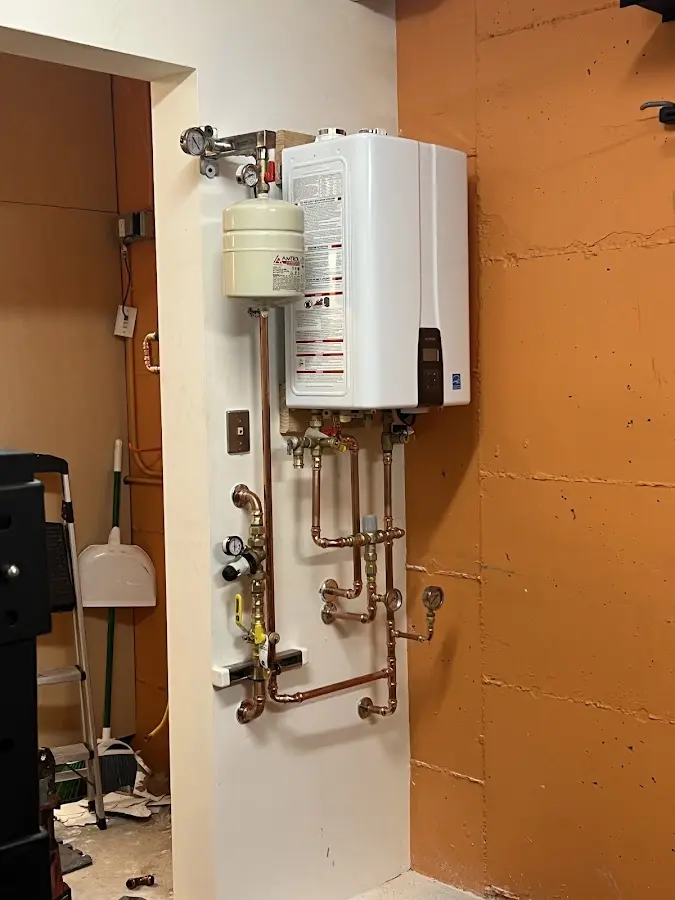 Plumbing technician inspecting water heater connections in Hamptonburgh